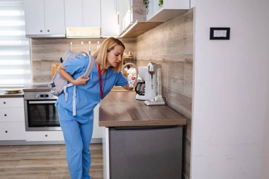 Uzun bir vardiyadan sonra mutfakta kahve molası vermekten yorgun düşmüş.