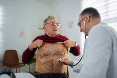 Doktor, zeki ve modern bir sağlık tesisinde yaşlı bir adamı muayene ediyor..