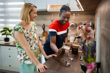 İki arkadaş modern, parlak bir mutfakta hayat dolu bir kahve yapma seansının tadını çıkarıyor. Kahkaha havayı doldurur, hikayelerini paylaşırlar ve zengin aromanın tadını çıkarırlar, birlikte unutulmaz anlar yaratırlar..