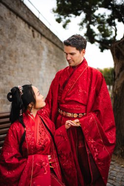 Düğün töreni için geleneksel Çin el işi kırmızı elbiseler giyen mutlu çift.