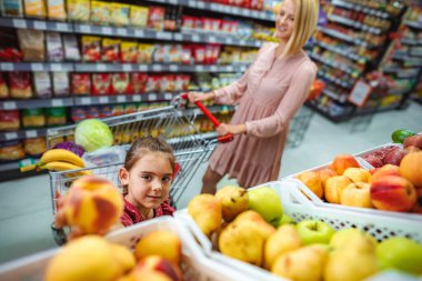 Family buying fresh fruits and vegetables in a supermarket
