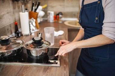Şef, mutfakta lezzetli bir yemek yapmak için modern mutfak malzemesi kullanıyor..