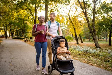 Neşeli bir çift dolambaçlı bir yolda el ele yürür, mutlu çocuklarıyla bir bebek arabasını iterler. Ağaçlar göz kamaştırıcı sonbahar renkleriyle giyinmiş, sıcak ve davetkar bir atmosfer yaratıyorlar..