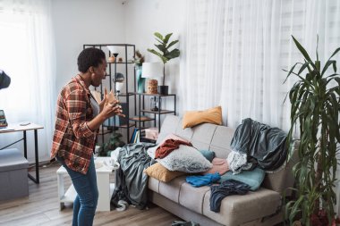 Hüsrana uğramış genç bir kadın dağınık bir apartman dairesinde bağırıyor.