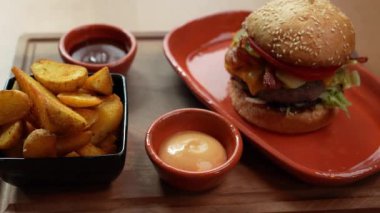 Patates dilimleri ve iki soslu gurme bir hamburgerle nefis bir yemek.
