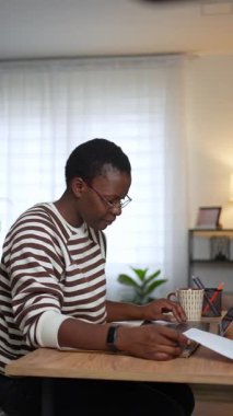 Genç bir kadın masasında oturuyor ve evrak işlerini dikkatlice inceliyor.