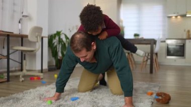 Sevecen bekar bir baba oturma odasında oğluyla oynayıp eğleniyor.