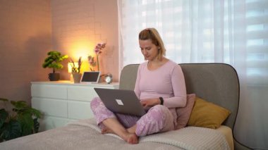 İki çok ırklı kadın iş kıyafeti giymiş dışarıda bir bankta oturmuş tablet üzerinde iş tartışıyorlar.