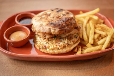 Taze kızarmış tavuklu sandviç, yanında da altın kızartma ve iki sosla nefis bir lezzet deneyimini davet ediyor..