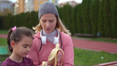 Mother and daughter take a short snack break together after finishing outdoor training