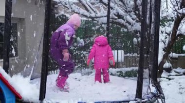 İki çocuk kış boyunca karlı bir trambolinde neşeli anların tadını çıkarırlar..