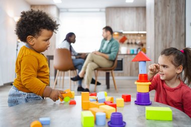 Ebeveynler dinlenirken çocuklar renkli engellerle uğraşır..