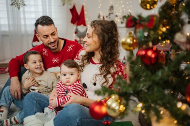 Ebeveynler ve iki küçük çocuk evde tatilin tadını çıkarıyorlar.