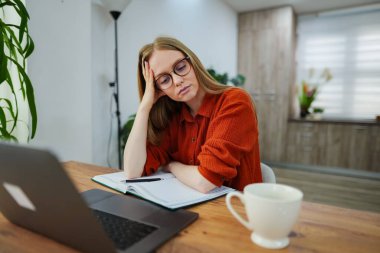 Genç bayan masasında bir fincan çayla özenle ders çalışıyor..