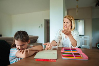 Anne hayal kırıklığı gösterirken kız göz temasından kaçınır..