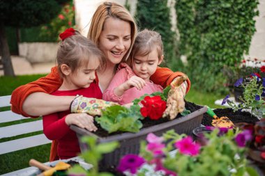 Bir anne bahçeyle ilgili mutluluğu kızlarıyla paylaşır..