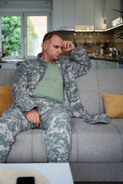 Depresyondaki subay evdeki koltukta oturuyor. Travma sonrası stres bozukluğu yaşıyor.