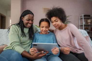 Kanepede mutlu bir aile bağı kurmak, dijital tablete bakıp gülümsemek.