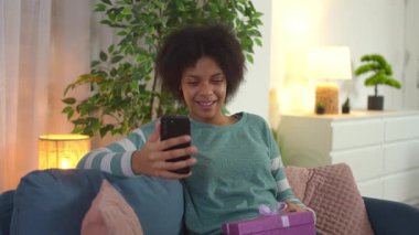 Gülümseyen Afro-Amerikan kadın doğum gününde bir video görüşmesi sırasında el sallıyor ve konuşuyor.