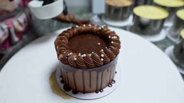 Kendini adamış bir öğretmen, bir çocuğa kek pişirme ve süsleme sürecinde rehberlik eder..