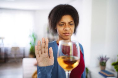 Genç bir kadın eliyle şarap içmeyi reddediyor.