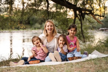 Mutlu bir aile nehir kenarında piknik yapıyor.