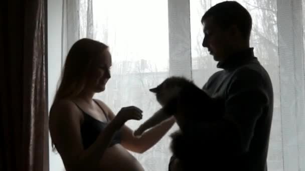 Zwangere vrouw met een man bij het raam. — Stockvideo