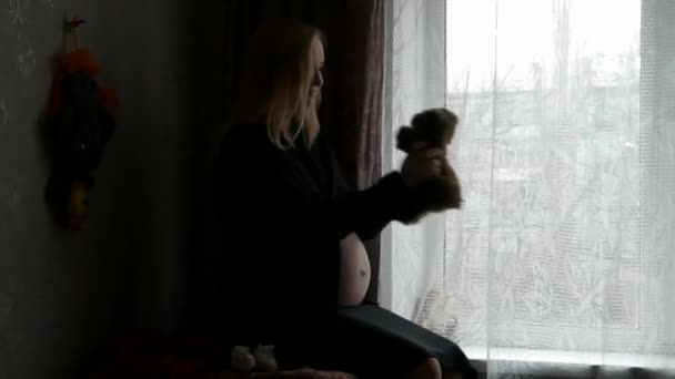 Pencerenin oturan bir hamile kadın. — Stok video