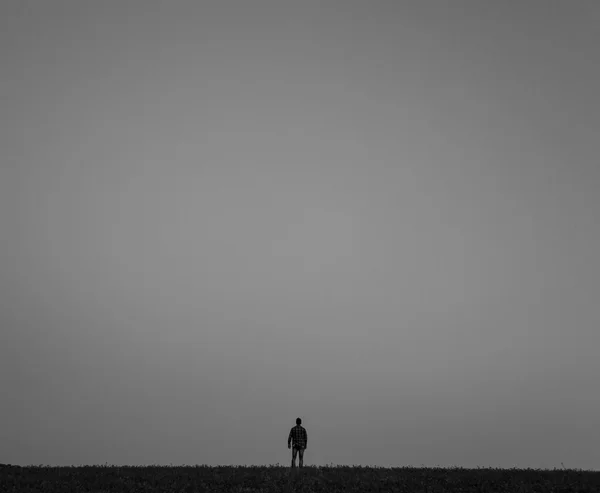 Yalnız adam ufukta standları.