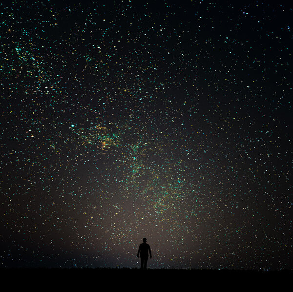 Silhouette of man looking at the stars. The man is on the horizon at night.Man desires guess looking at the stars.