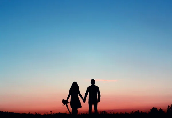 Silhouetted kochająca para o zachodzie słońca — Zdjęcie stockowe