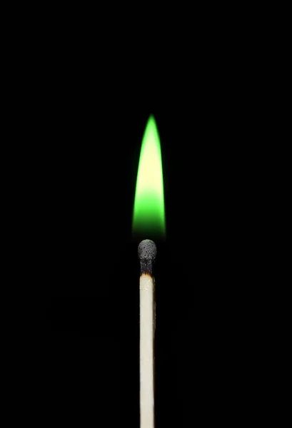 Burning match close-up on a black background. Green fire. — Stock Photo, Image