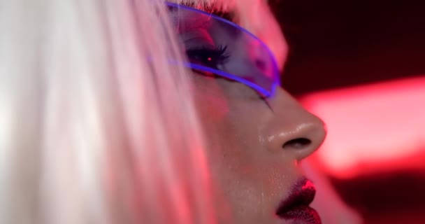 Cyberpunk portrait of a blonde with futuristic glasses. — Stock Video