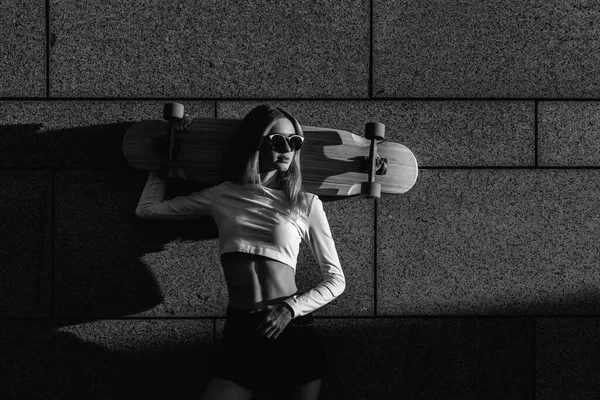 Schwarz-weißes Porträt einer jungen Frau mit Longboard. — Stockfoto