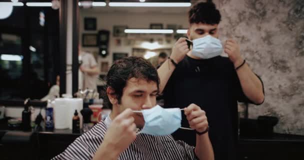 理发师和客户都戴上了防毒面具.男子在检疫方面的理发. — 图库视频影像