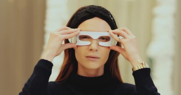 Woman wearing face beauty LED glasses — Stock Video