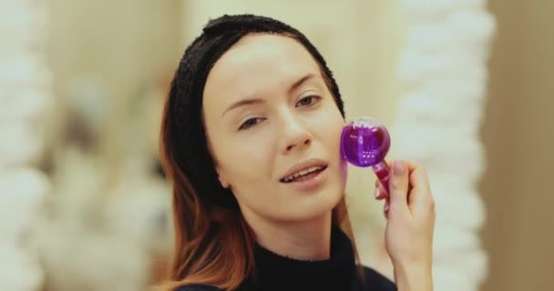 Femme massant son visage avec des globes de glace faciale — Video