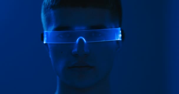 Mänskliga ögon genom glasögon. Cyberpunk porträtt av en ung man. — Stockvideo
