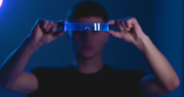 Un joven se pone un gadget cibernético en la cabeza. — Vídeos de Stock