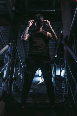 Gece otoparkında dövmeli bir adam. Siber punk tarzı. Siber teknolojisi olan adam..