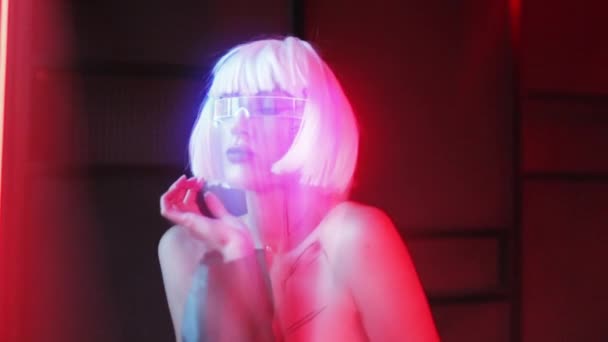 Proyección rosa neón de una mujer en gafas futuristas. Neon noir. — Vídeos de Stock