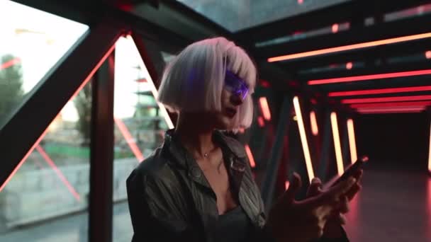 Mulher em óculos cibernéticos usa um gadget, telefone. — Vídeo de Stock