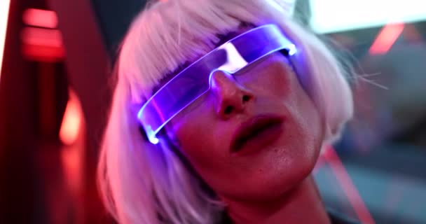 Cyberpunk woman with closed eyes and blue neon glasses. — Stock Video