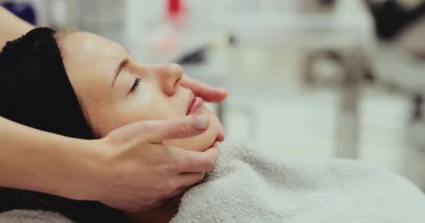 Masaje facial suave en un salón de belleza. — Vídeos de Stock