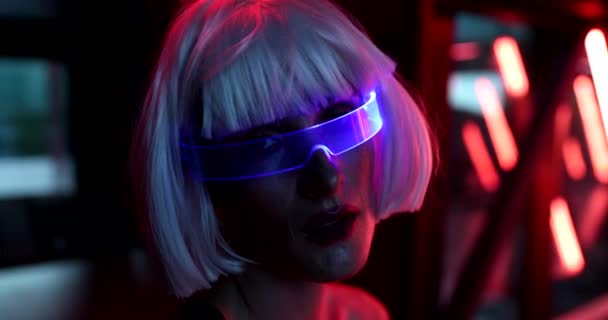 Seni cyberpunk video dengan seorang wanita dalam kacamata bercahaya. Video ini memiliki efek dari gandum, kebisingan. — Stok Video