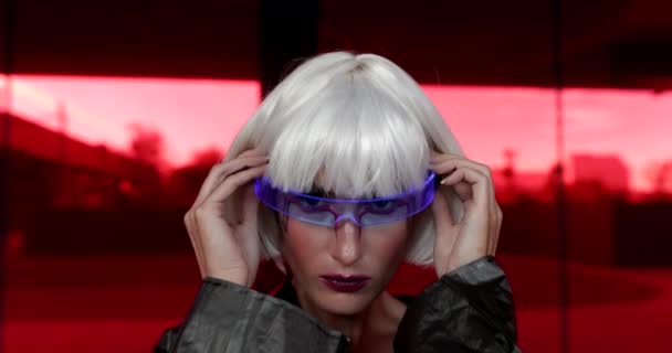 Mujer lleva las gafas del futuro sobre un fondo rojo — Vídeo de stock