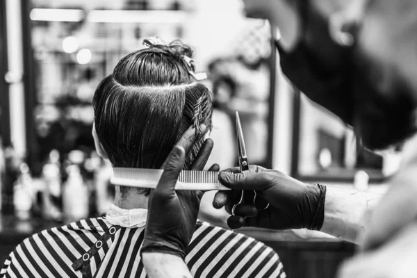 Peluquería hace un corte de pelo y peinado en una peluquería, salón de belleza. —  Fotos de Stock