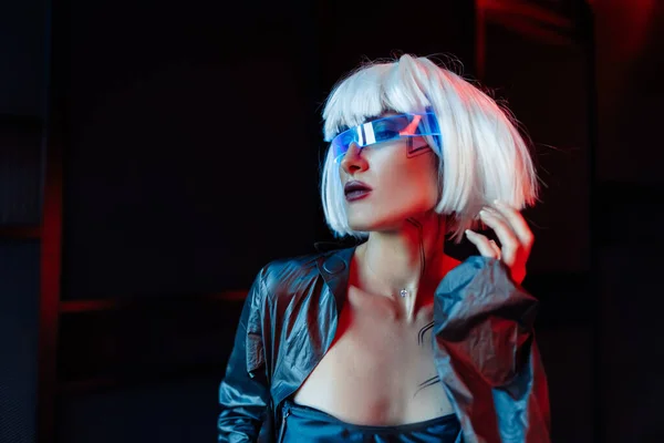 Blonde in cyberpunk style. Futuristic glasses on a woman. — Stock Fotó