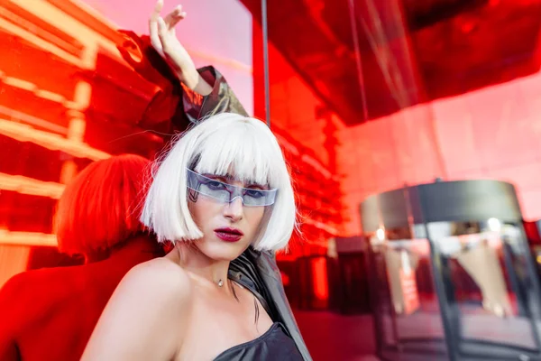 Futurisztikus stílus. Nő szemüveggel és közel egy piros futurisztikus épület. — Stock Fotó
