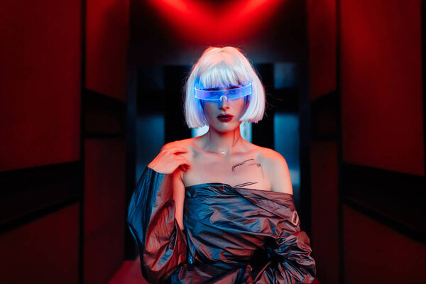 Cyberpunk blonde in neon glasses.